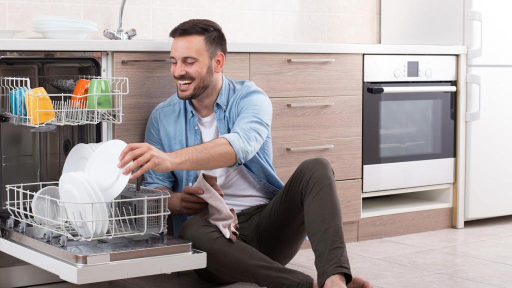Un hombre poniendo el lavavajillas