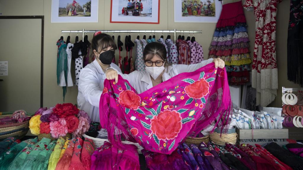 Dos dependientas enseñan un mantoncillo.