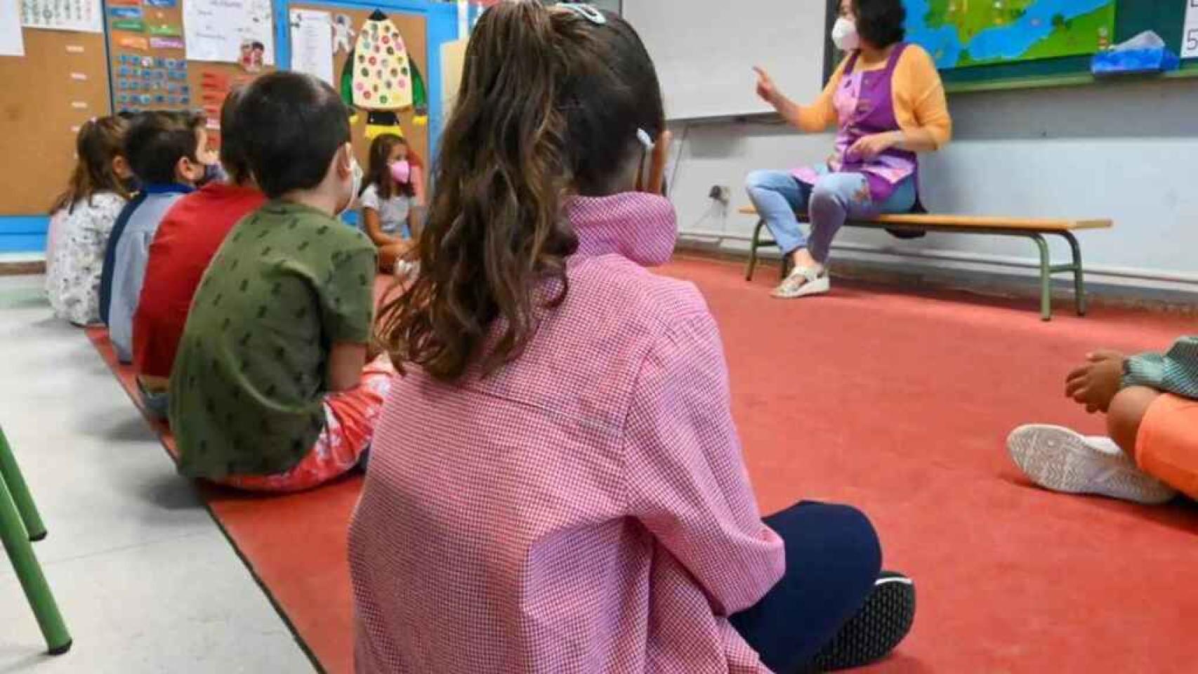 Niños pequeños con mascarilla en un aula en León.