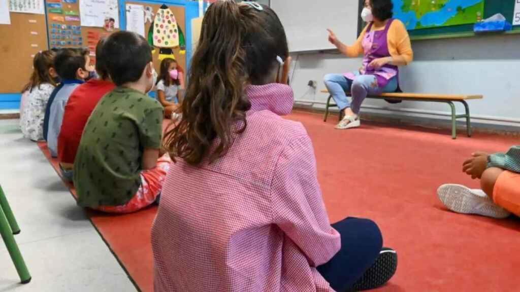 Niños pequeños con mascarilla en un aula en León.