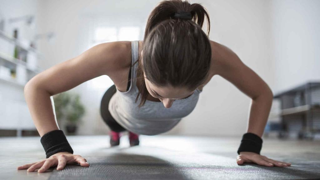 Una mujer hace flexiones.