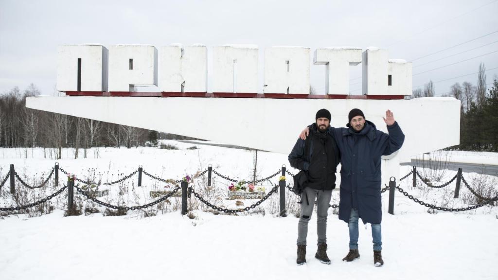 Raúl Moreno y su guía Olexander ante el cártel de entrada a la ciudad de la abandonada ciudad de Prípiat, en la zona de exclusión.