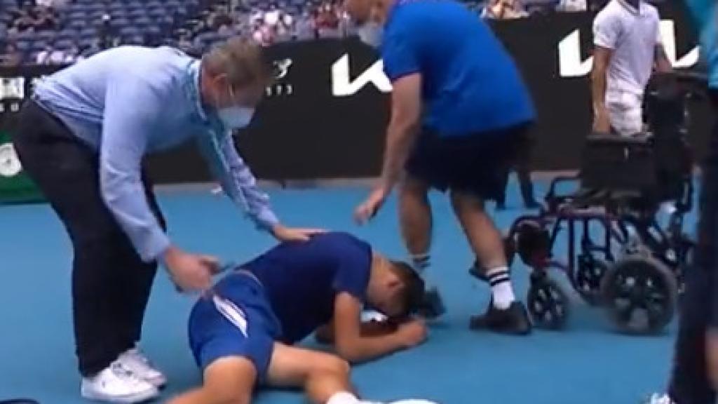 Jakub Mensik sale en silla de ruedas de la pista del Open de Australia