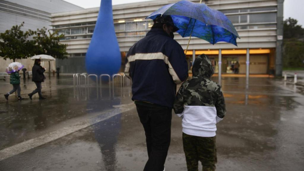 Un niño acompañado de su padre, a su llegada al recinto ferial Expourense para ser vacunado.