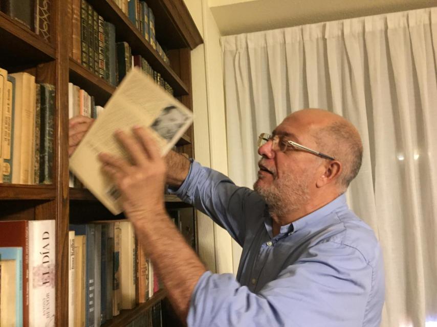 Igea busca un libro en su biblioteca.