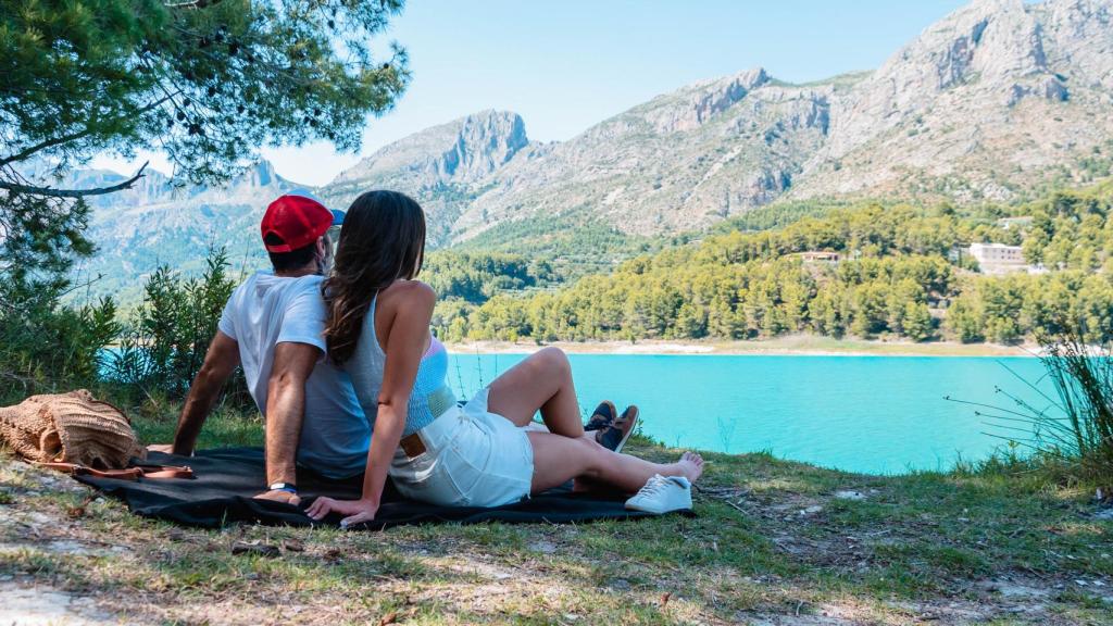 Una pareja disfruta de las vistas del embalse de Guadalest, Alicante.