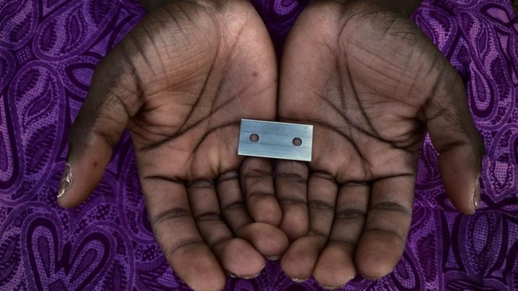 Una mujer sujetando las láminas con las que practica la MGF.