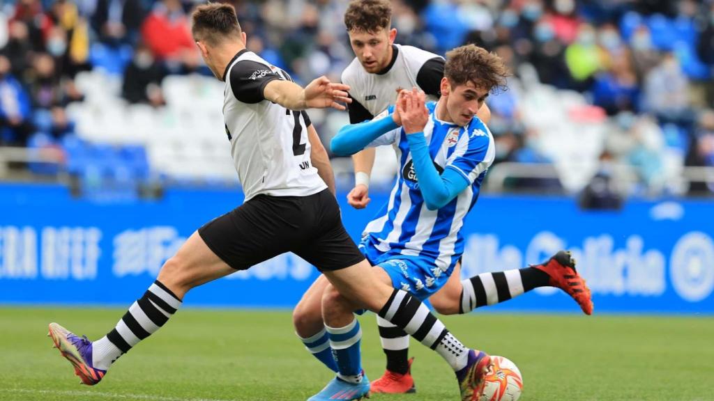 Noel pugna un balón ante dos jugadores del Real Unión de Irún.