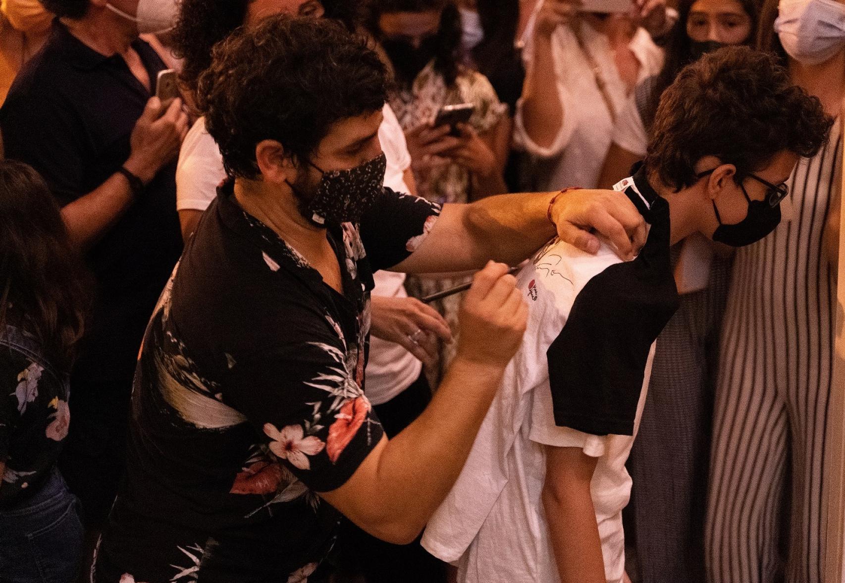 Fran Perea le firma la camiseta a un joven fan.