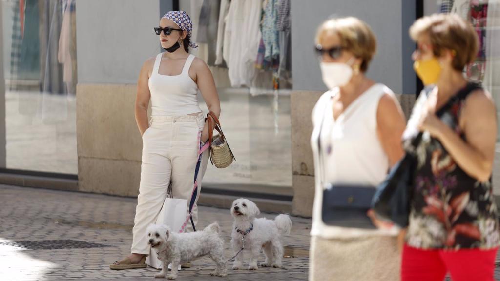Personas sin mascarilla y otras con mascarilla en la calle Larios,