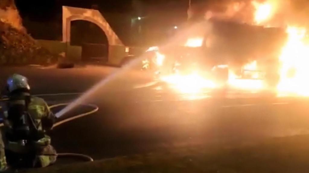 Los bomberos apagan el camión de la basura incendiado en el Paseo Marítimo de A Coruña.