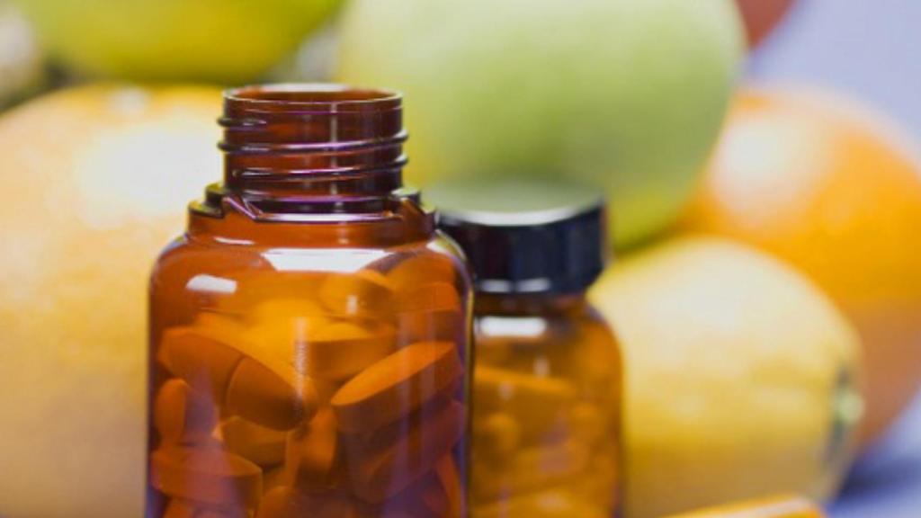 Dos botes con vitaminas en comprimidos.