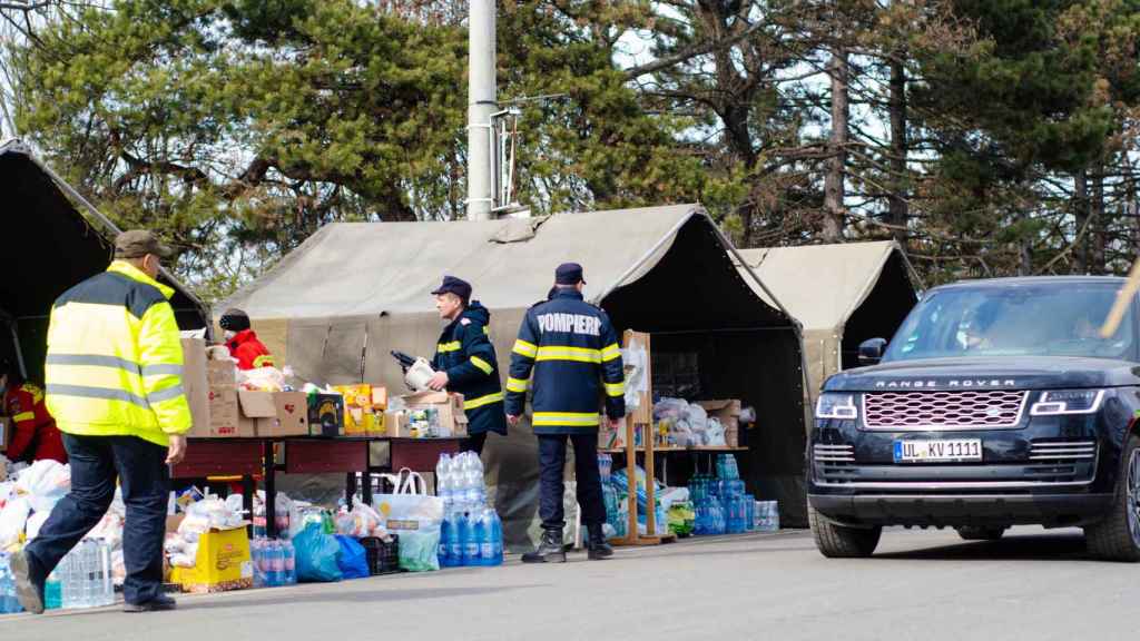 Refugiados de Ucrania ayudados por voluntarios en la frontera con Rumanía.