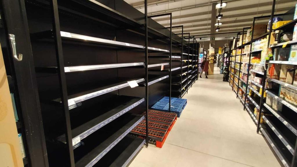 Un pasillo de leche de un supermercado completamente vacío.