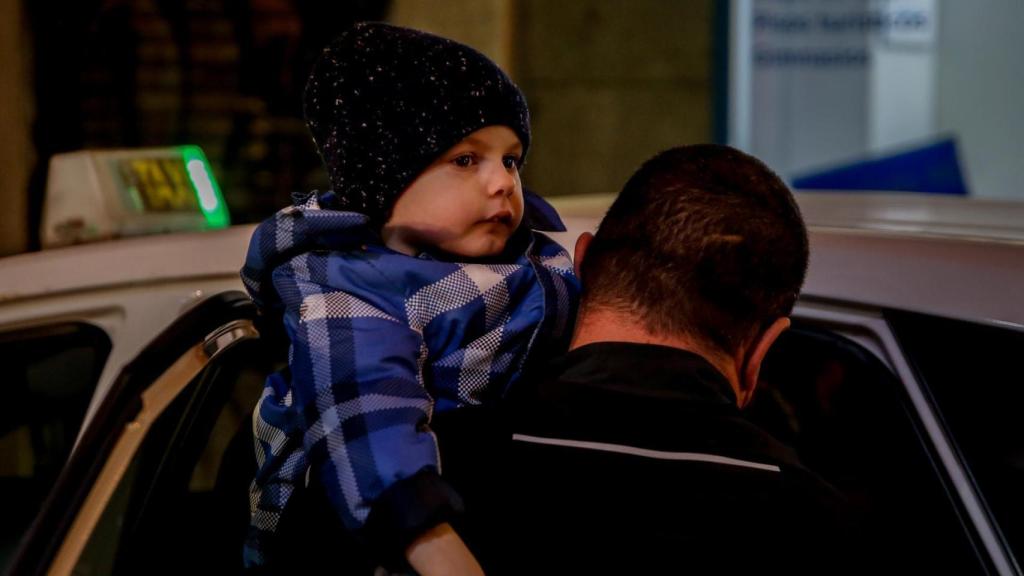 Un taxista sostiene en brazos a un niño ucraniano a su llegada a Madrid.
