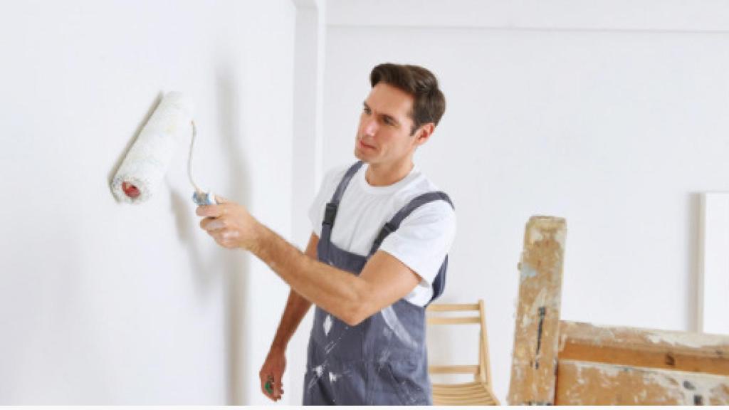 Un hombre pintando la pared.