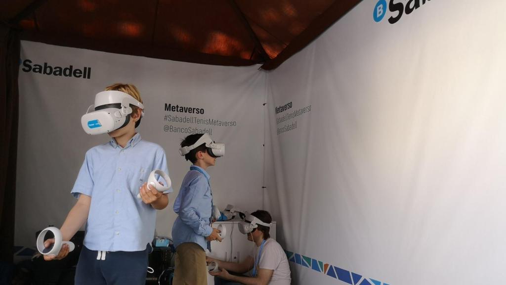 Dos jóvenes asistentes al recientemente celebrado torneo de tenis Conde de Godó, disfrutan del metaverso de Banco Sabadell y Accenture.