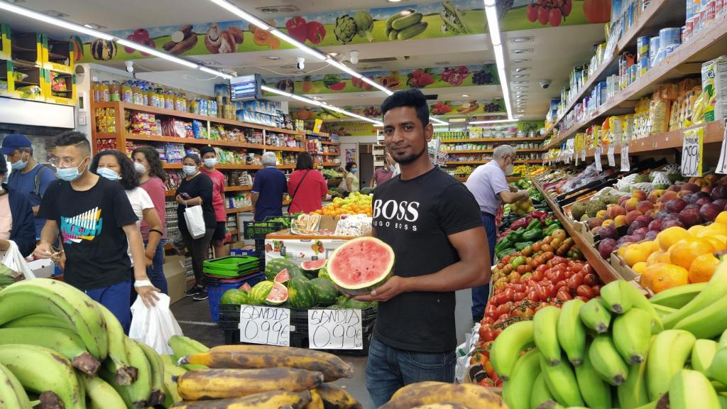 Mithu Sheik posa con una sandía en su frutería.