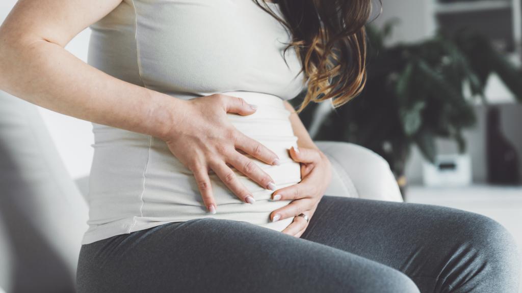 Mujer embarazada tocándose el vientre.