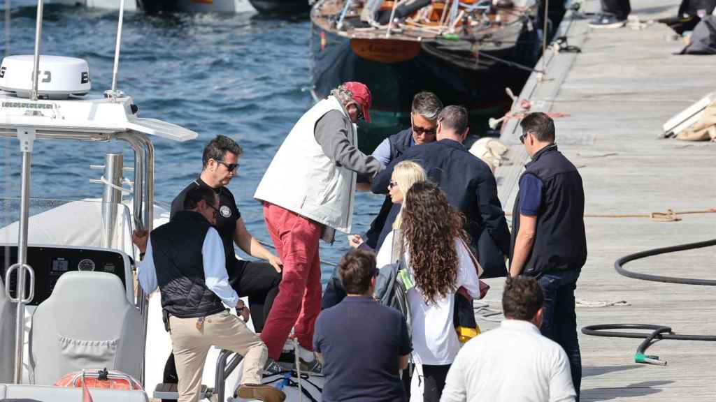 Juan Carlos I desembarca de la lancha auxiliar con ayuda de la tripulación.