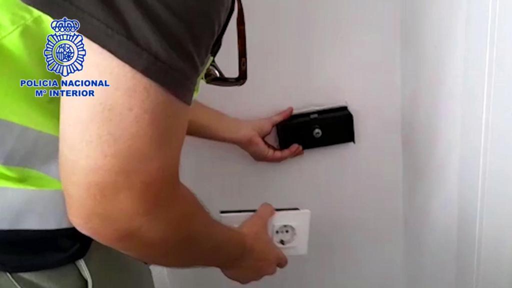 Un agente descubre una caleta de un falso enchufe donde se guardaba el dinero.