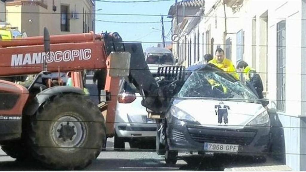 Imagen del coche del cobrador del frac destrozado por el toro mecánico.