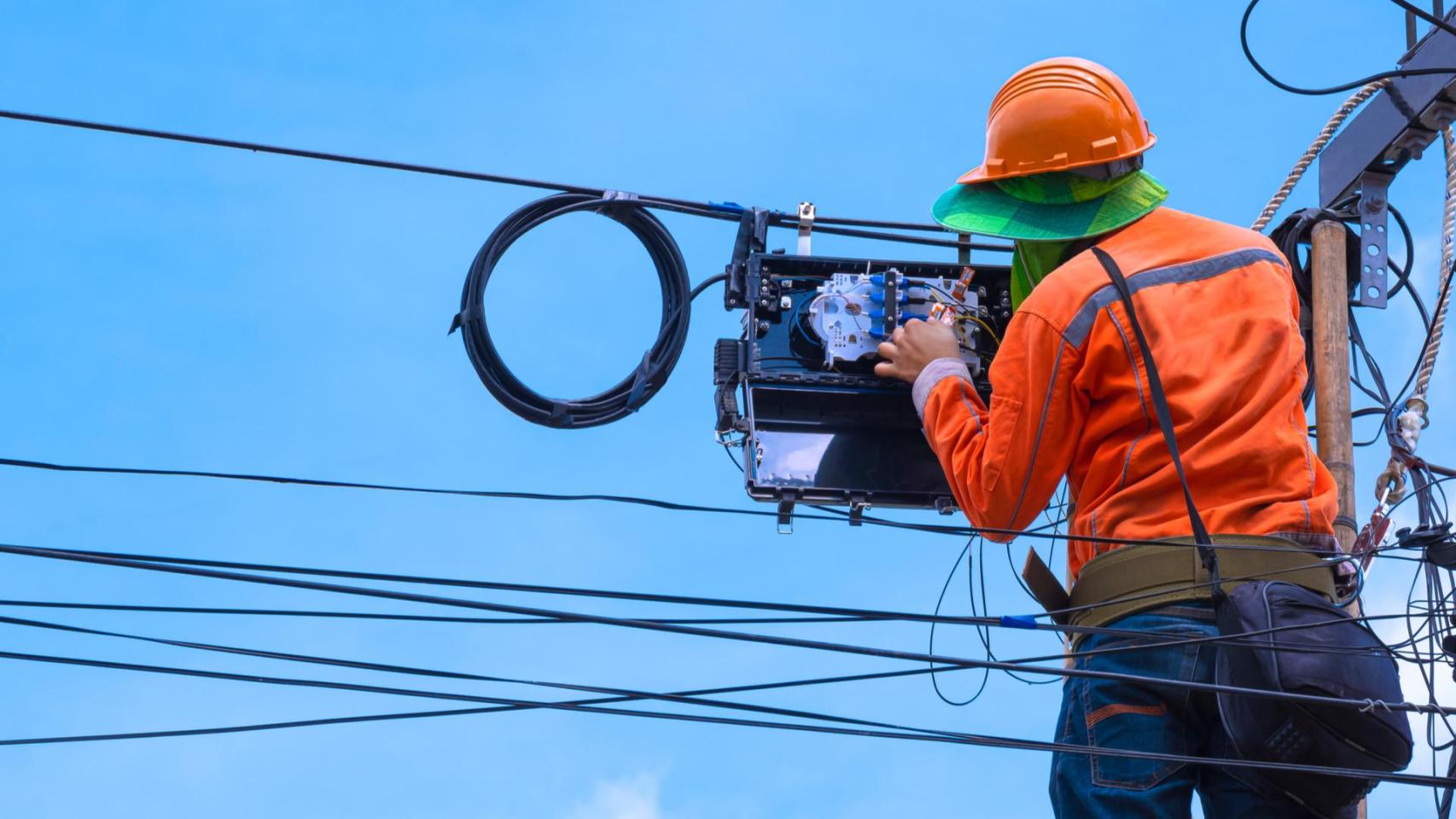 Operario instalando fibra óptica en imagen de archivo.