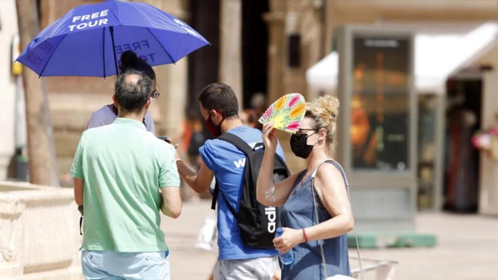 Una mujer refugiándose del calor en la Plaza de la Constitución.