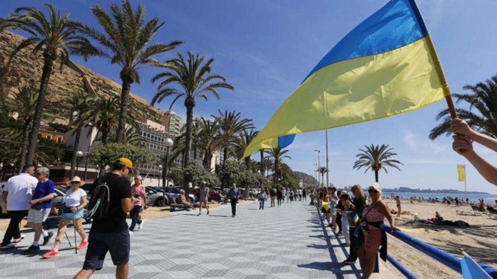 Acto en la playa del Postiguet con la bandera de Ucrania, en la que se formó una cadena humana.
