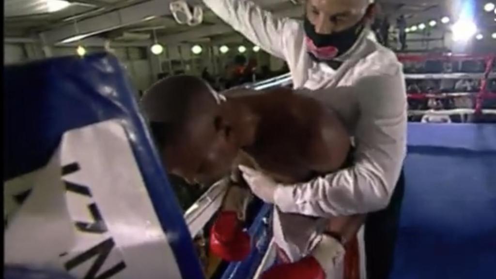 El boxeador Simiso Buthelezi sujetado por el árbitro
