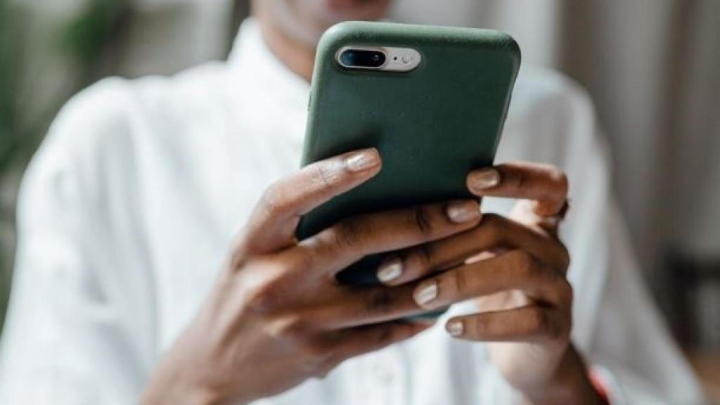 Una mujer utilizando su teléfono móvil (smartphone).