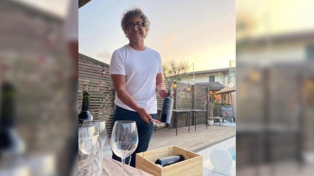 'Capi', el empresario vitivinícola detenido por la Policía Nacional, mostrando una botella de vino.