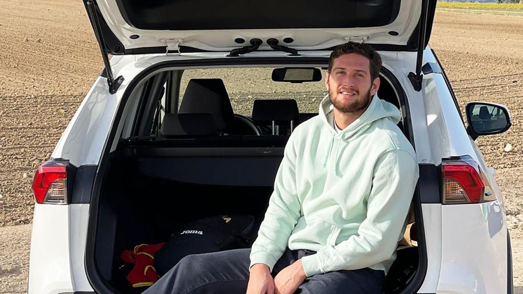 Niko Shera junto con su Toyota RAV4 híbrido.