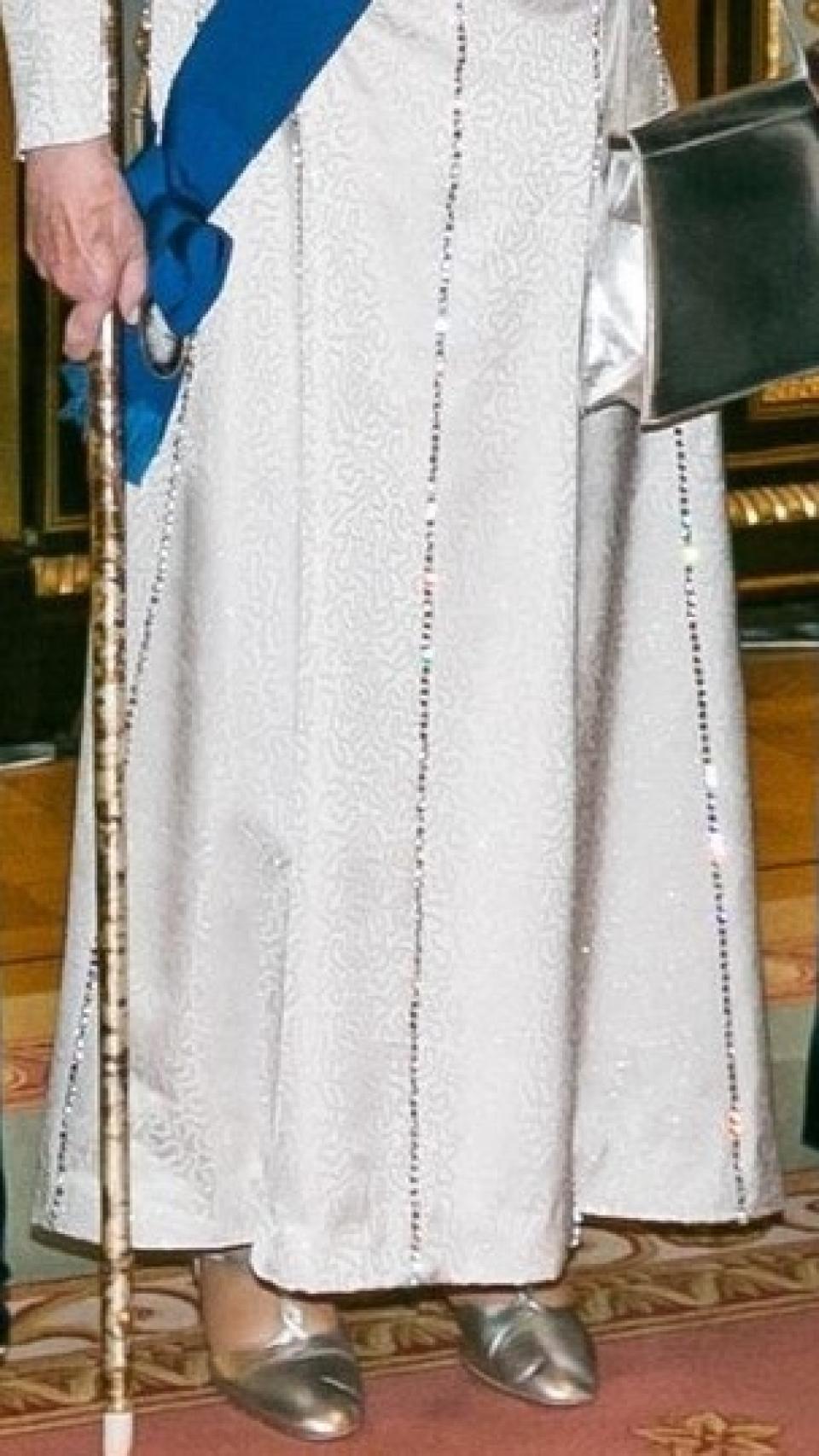 Isabel II, con zapatos y bolso plateados.