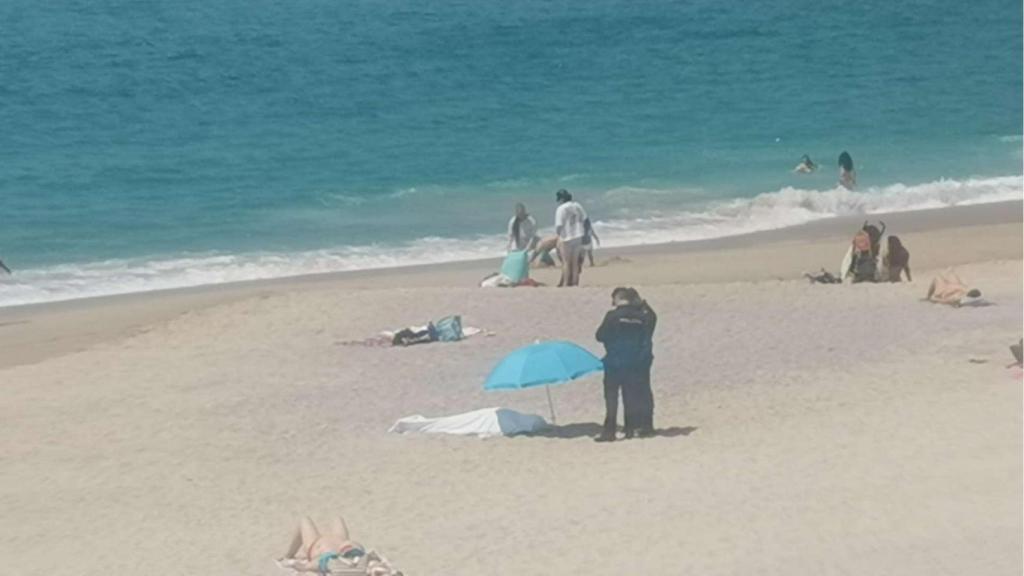 Cuerpo postrado en la arena junto a los efectivos de la Policía Nacional