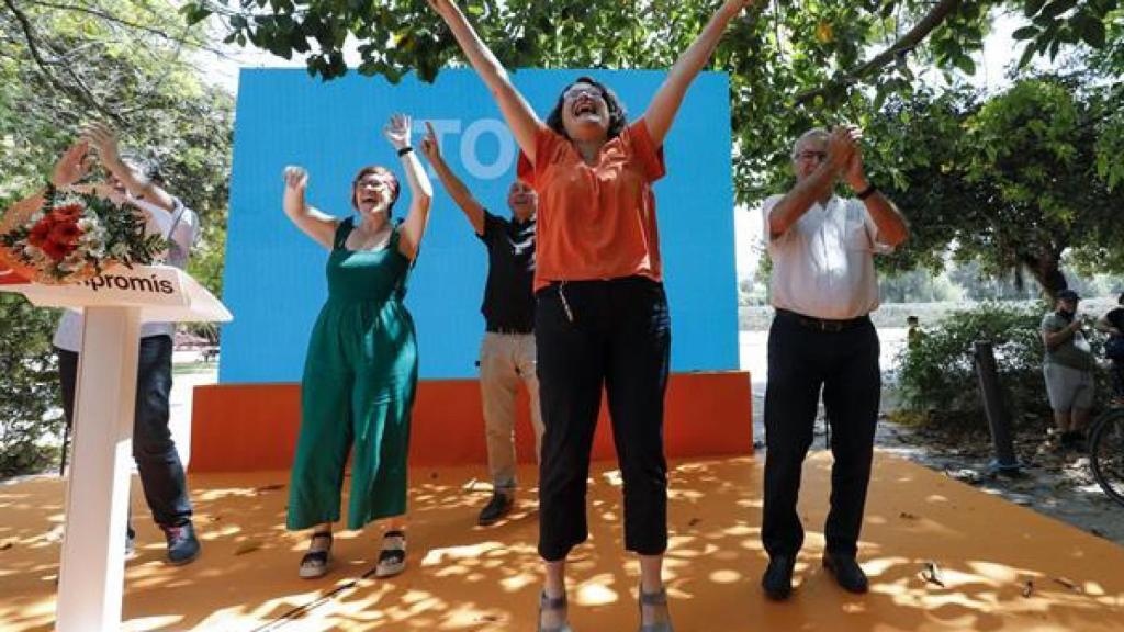 Oltra levanta los brazos en el acto.