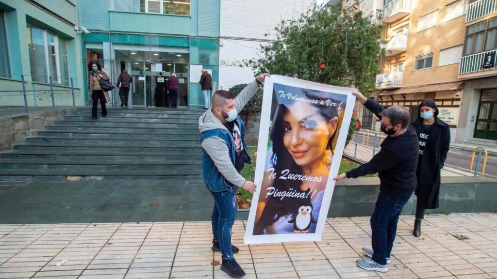 Rubén, junto a su padre, Damián, en los juzgados de Cartagena, desplegando una foto gigante de su hermana Sara.
