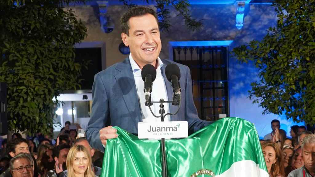 El candidato del PP, Juanma Moreno, con una bandera de la Andalucía en la noche del 19-J.