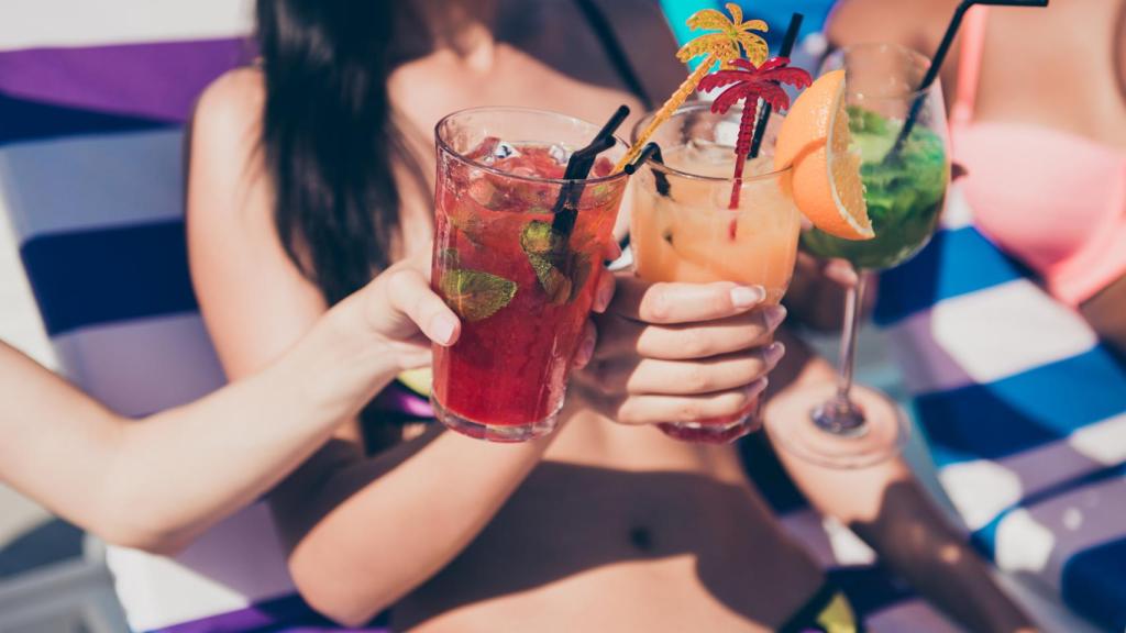 Tres cócteles que disfrutan tres amigas en la piscina.