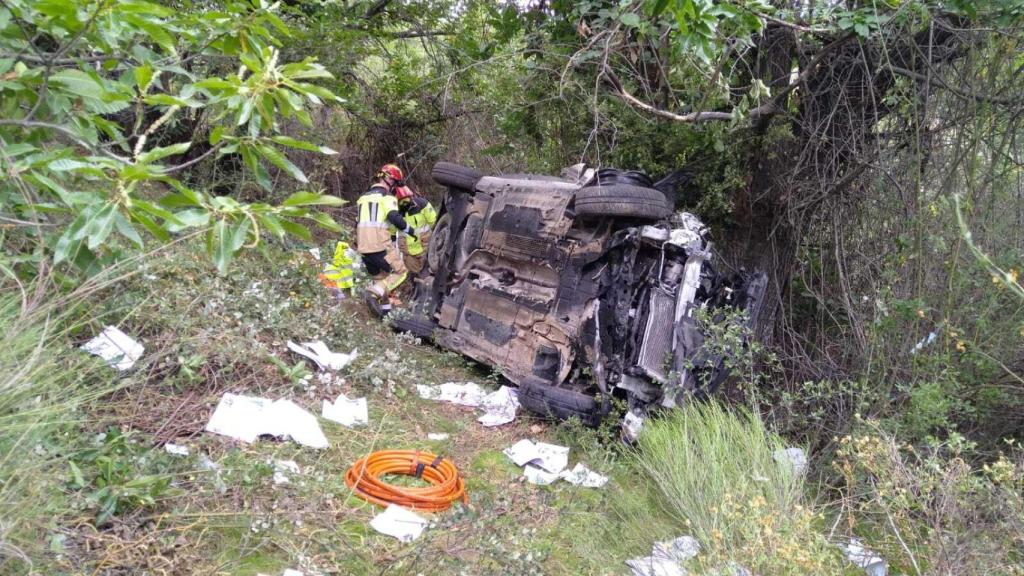 Los equipos de rescate tratan de sacar al herido del vehículo accidentado