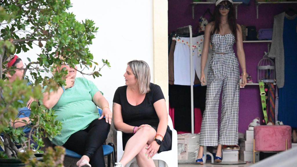 Tres mujeres charlan en la puerta de un establecimiento en Alcalá de los Gazules.