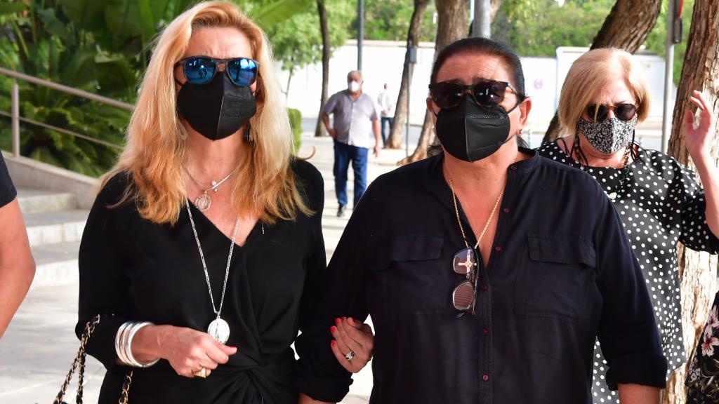 María y su pareja, del brazo, en el entierro de la madre de María,