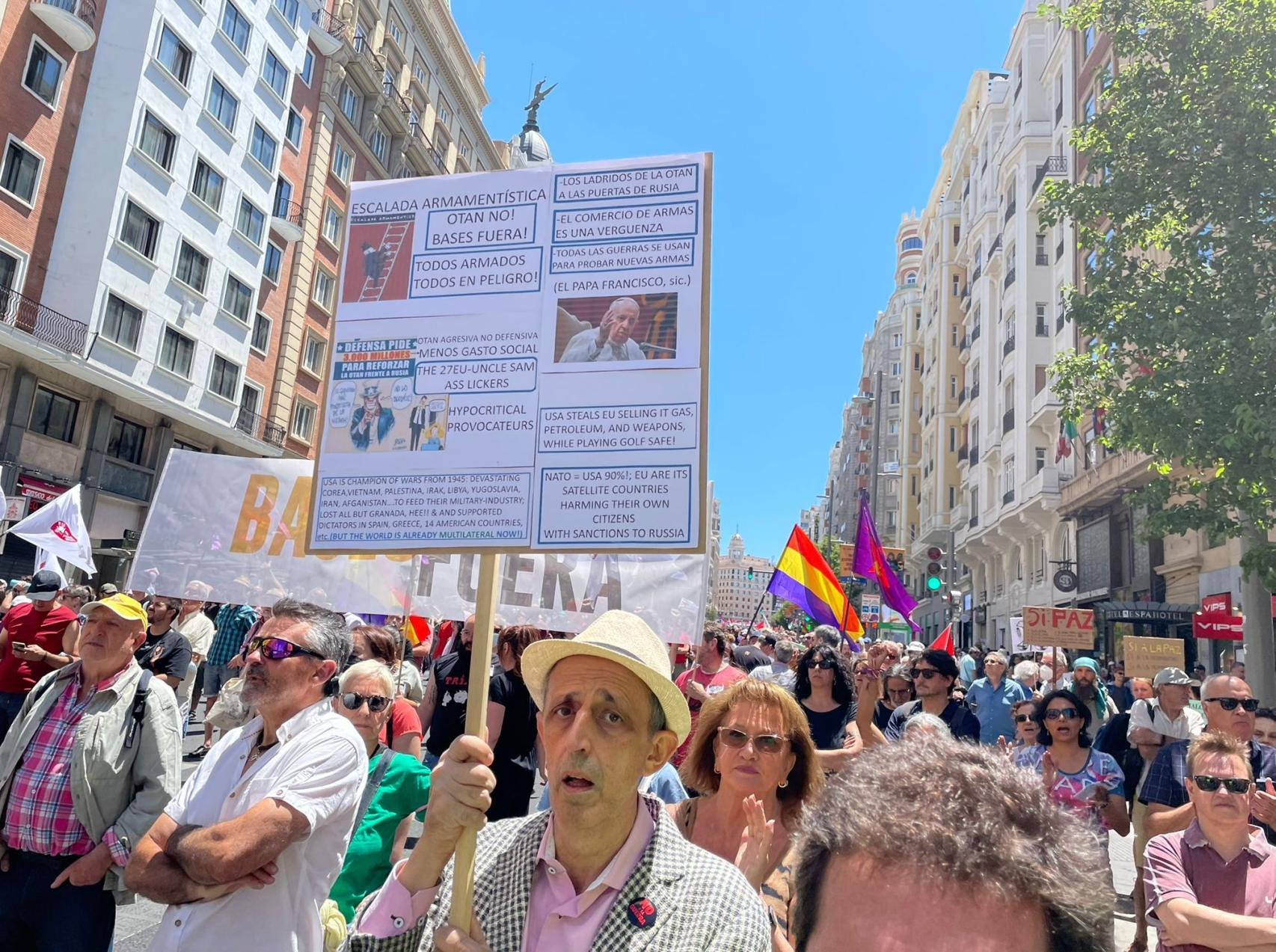 Uno de los manifestantes exhibe un pancarta contra la OTAN.
