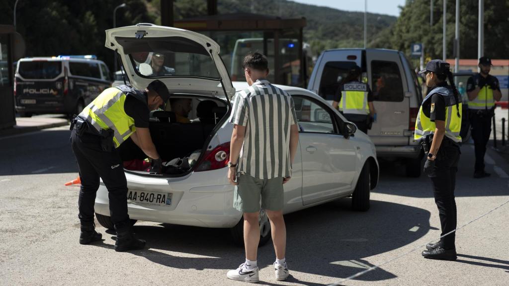 Agentes de la Policía Nacional, este martes, revisando a fondo el coche de un conductor.