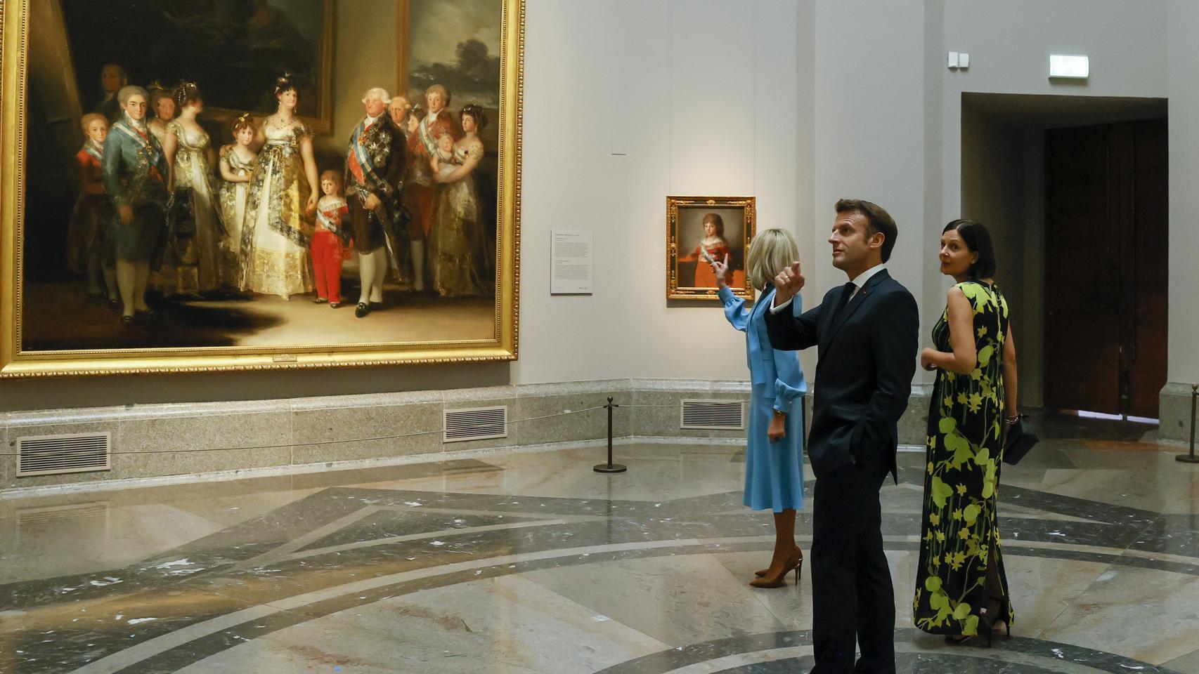 El presidente francés, Emmanuel Macron (c), su mujer, Brigitte Macron (i), y Annik Penders (d), esposa del primer ministro belga, Alexander De Croo, a su llegada al Museo del Prado donde el presidente del Gobierno español, Pedro Sánchez, ofrece una cena a los jefes de Estado y jefes de Gobierno que participan en la cumbre de la OTAN, este miércoles en Madrid.