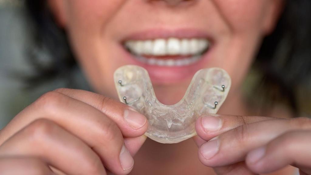 Una mujer sostiene frente a ella su férula de descarga.