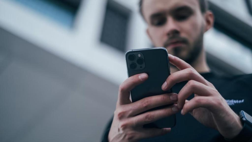 Un joven usando su teléfono móvil.