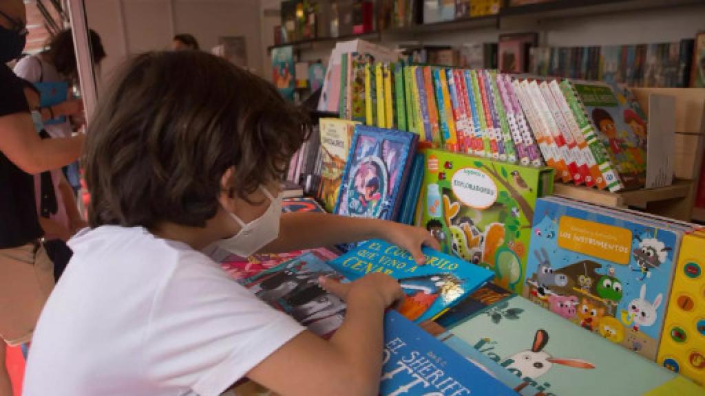 Un niño ojea libros.