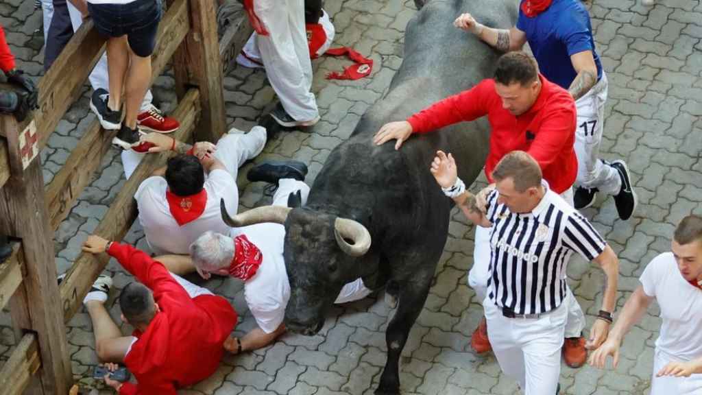 Los mozos corren ante los toros de la ganadería de José Escolar durante el tercer del encierro de San Fermín, este sábado.