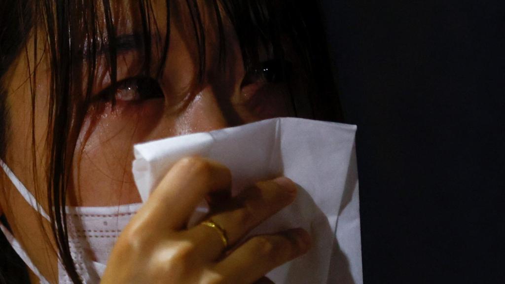 Mujer llora por el asesinato de Abe.